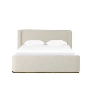Fane Bed with cushioned neutral-tone fabric upholstery, plinth ash base, and soft, curved head and footboards.