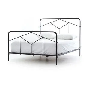 Black iron bed with geometric headboard and footboard, simple tubing, low-profile frame with white bedding