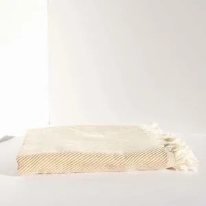 Jordan Bath Towel folded, tan color with subtle stripes and fringed edges, cotton fabric